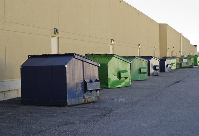 tilted front-load dumpsters being emptied by waste management workers in Borger TX